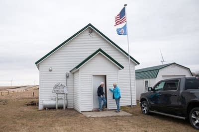 People stand outside of a white building