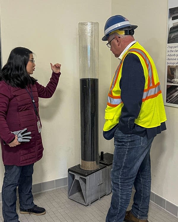 Two person look at a model of water purification instrument