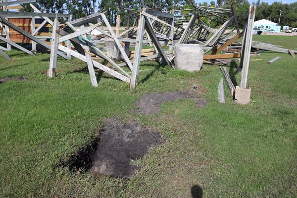A hole is seen where a concrete base used to be. It sits feet away next to wooden wreckage.
