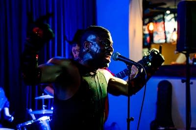A man gestures and sings onstage in a music venue