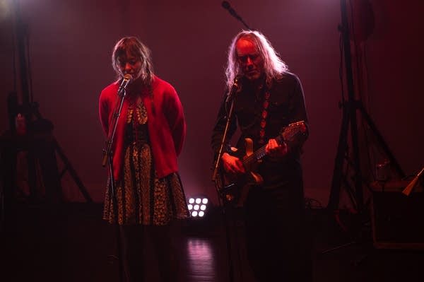 Two musicians performing onstage in a theater