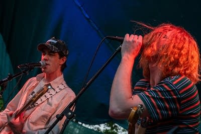 A rock band performing on an outdoor stage