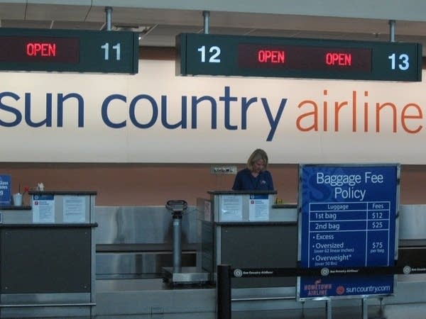 An employee works behind a check-in kiosk.