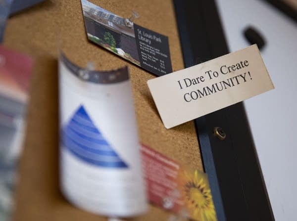 A card on a bulletin board says "I dare to create community."