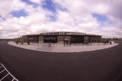 An outdoor amphitheater with a stage under a partial roof.