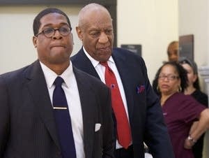 Bill Cosby (C) walks through the Montgomery County Courthouse