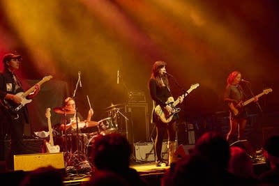 A band performing onstage in a large music venue 