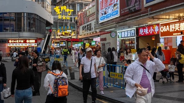 Shoppers walk on a street at a shopping district in China.