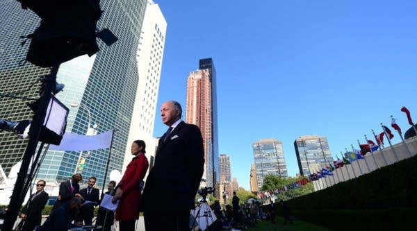 French Foreign Minister Laurent Fabius (C) gets ready to do a live television interview in front of the United Nations headquarters ahead of the start of the 68th UN General Assembly, in New York, September 23, 2013. 