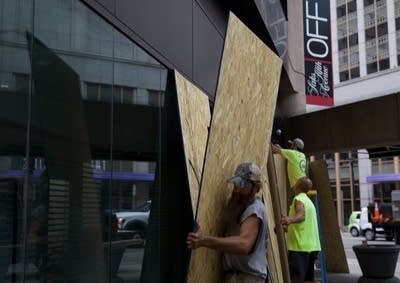 Workers board up windows. 