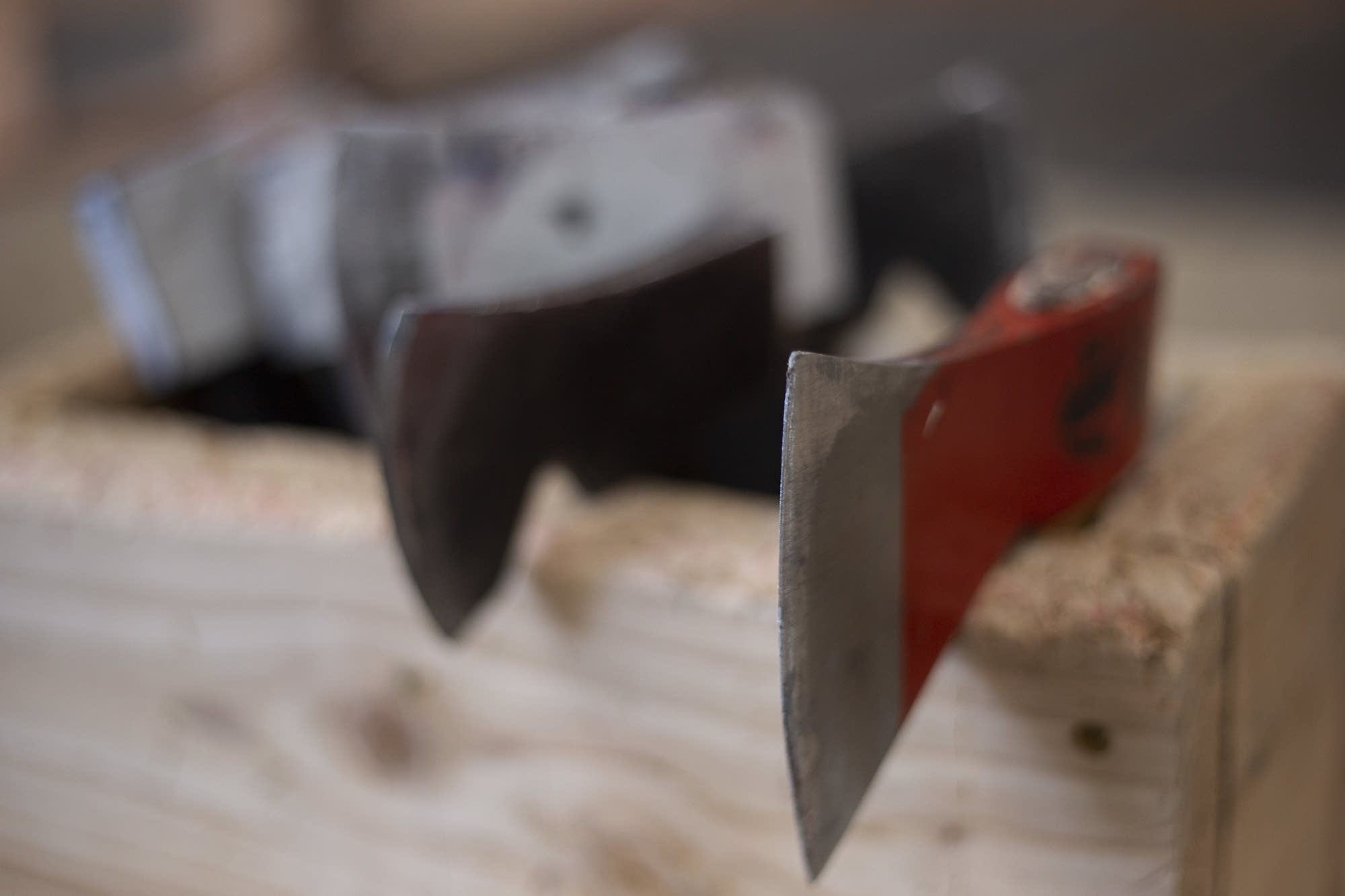 Axes sit in a wooden bin in every throwing booth at Bad Axe Throwing.