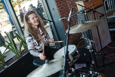 A musician plays drums in a taproom 