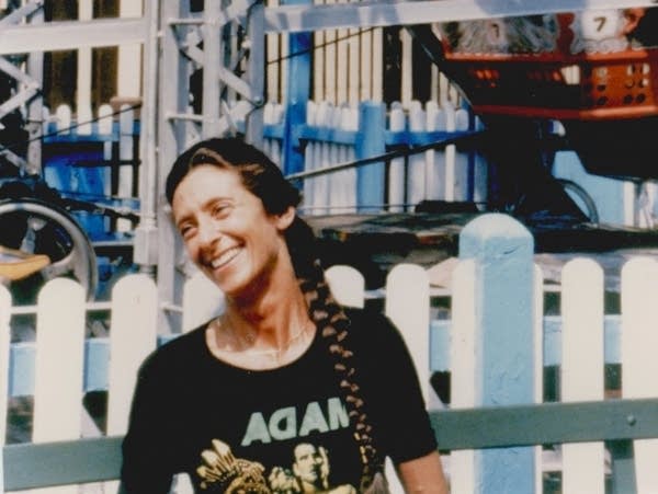 An album cover featuring a woman smiling in front of a Ferris wheel.