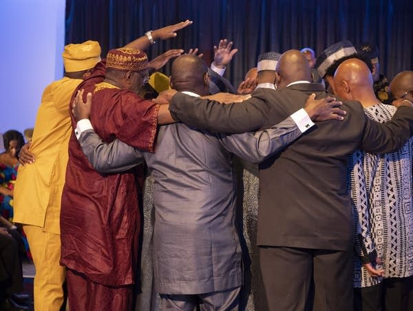 Mentors and initiates huddle in a circle during