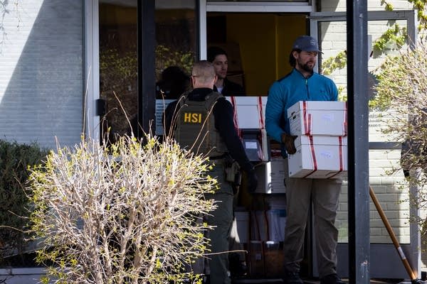 Agents load evidence into a vehicle