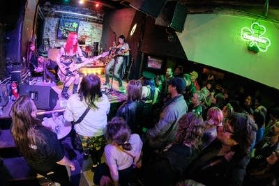 Five musicians performing onstage