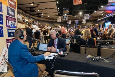 Two people speak into microphones at the convention.