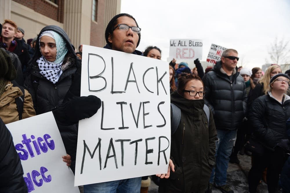 Mario Cruz holds up a sign among protesters