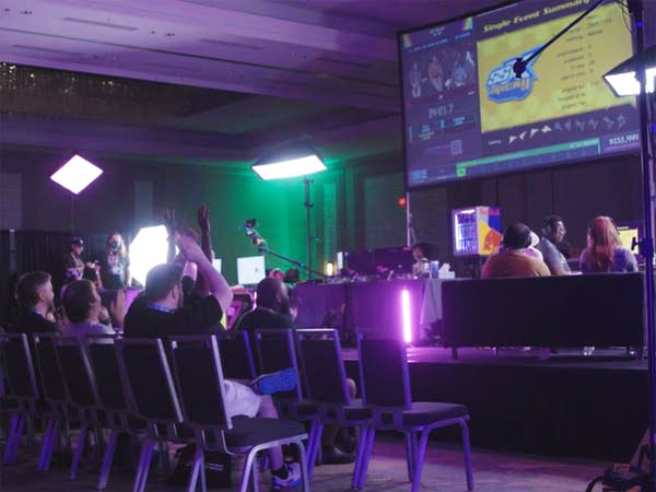 The audience applauds for a video game speedrunner up on stage.