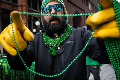 A man hands out a bead necklace