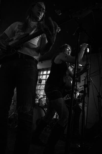 A rock band performing inside a small bar venue