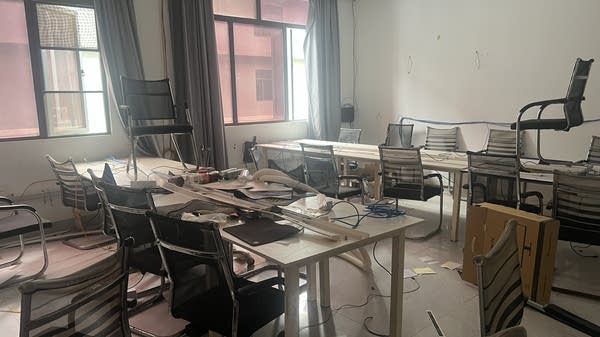 A messy office with chairs on top of tables