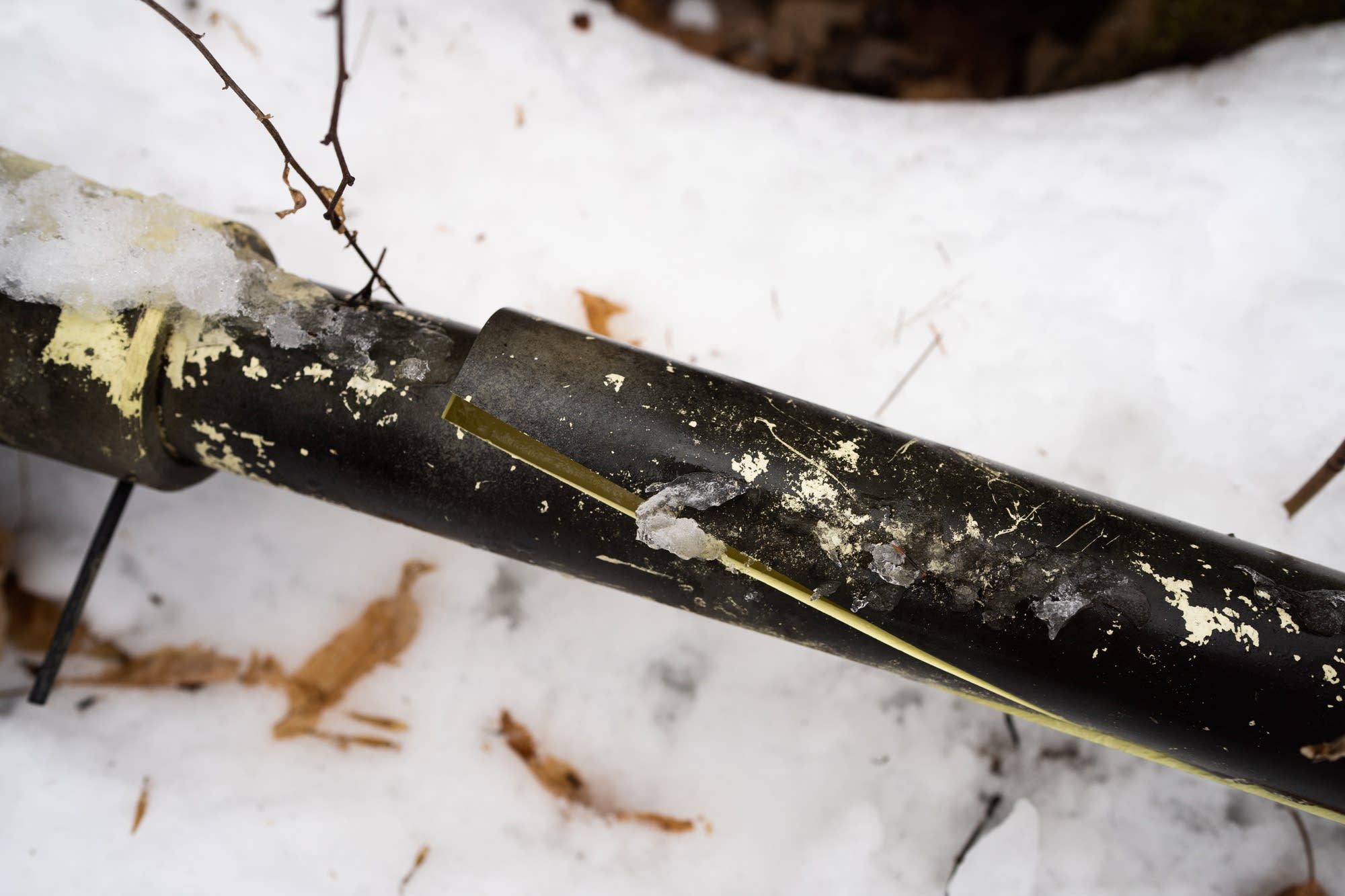 A pipe used to farm ice for climbing sits filled with ice.