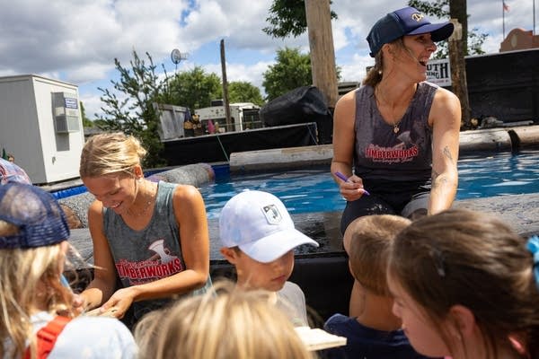 Two women sign wood chips