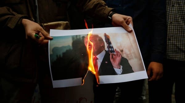 Iranians burn an image of US President Donald Trump during an anti-US demonstration outside the former US embassy headquarters in the capital Tehran on May 9, 2018.