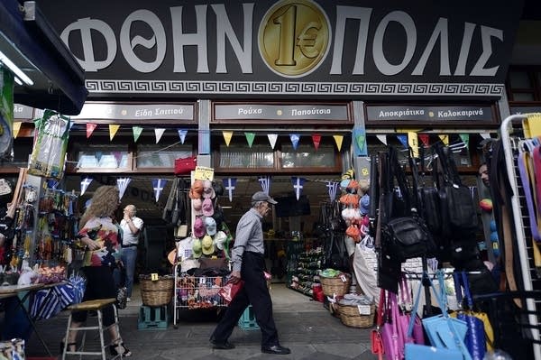 A man walks past a "one euro" store in central Athens on July 2, 2015. Greece's left-wing government "may very well" resign if a referendum this weekend on bailout conditions results in a 'Yes' vote, Finance Minister Yanis Varoufakis said in a radio interview on July 2. AFP PHOTO / LOUISA GOULIAMAKI        (Photo credit should read LOUISA GOULIAMAKI/AFP via Getty Images)
