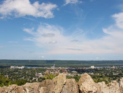 A blue sky is above a scenic view of a valley.