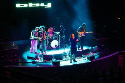 A five-piece band performing together onstage