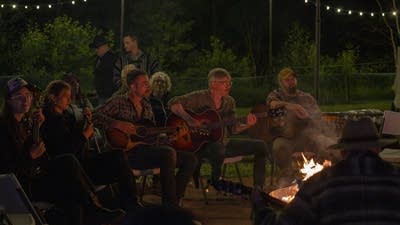 Crowd gathering around a campfire