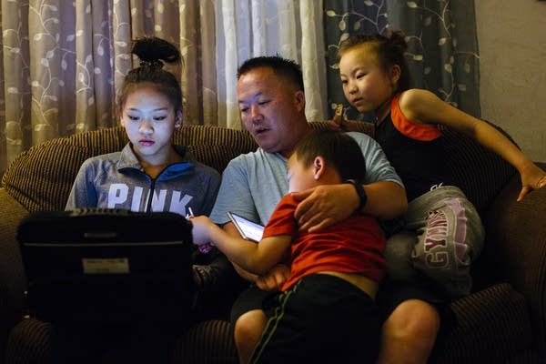 Sunisa Lee does homework on the couch with her family. 