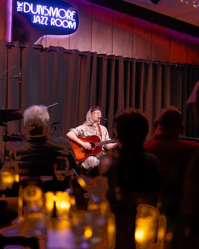 Lambchop performs seated on a stage.
