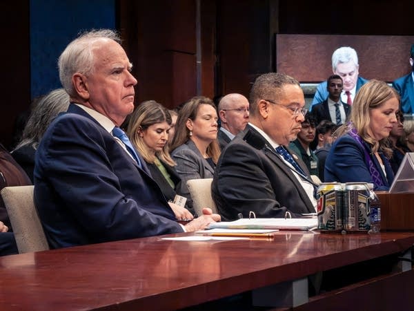 Two people sit in a hearing.