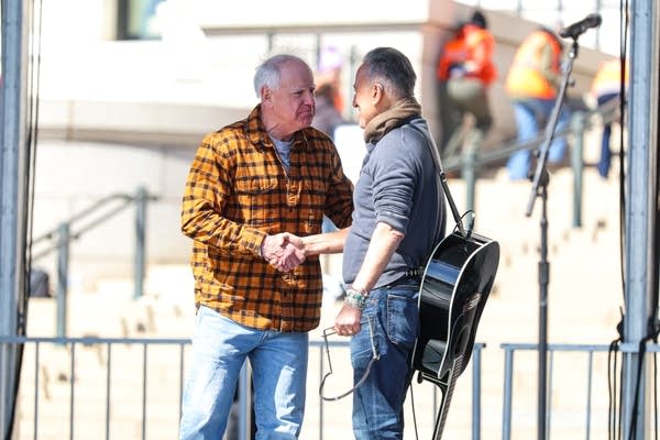 Two men shake hands