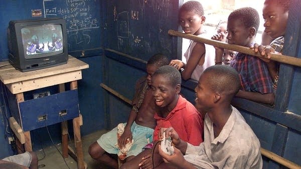 Children in Abidjan, the largest city in Ivory Coast, gather in a shed to play a PlayStation game.