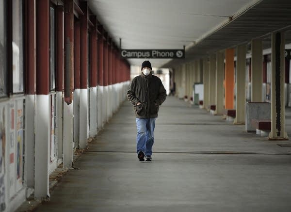 A person wearing a mask while walking. 