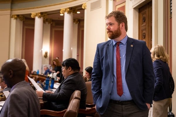 A man walks past seated representatives
