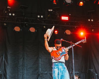 Devon Gilfillian performing with a guitar on stage