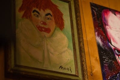 A painting of a clown mounted to a wall 