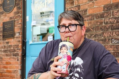 woman sits outside drinking from water bottle 