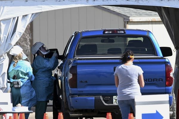 Medical workers administer drive-up tests. 