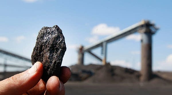 A piece of coal is held up at the Savage Energy Terminal on Aug. 26, 2016 in Price, Utah.