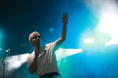 A man sings and gestures onstage
