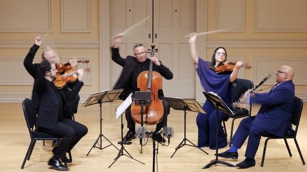 Poster Members of the Dali Quartet perform on a light wood stage