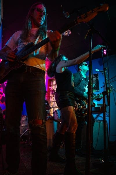 A rock band performing inside a small bar venue