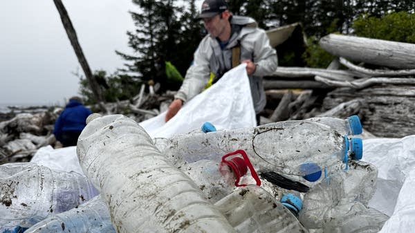 Single-use plastic bottles wash up on Alaska’s Montague Island by the thousands each year. Eric Pallister, in the background, said that despite years of cleanup efforts, it is impossible to catch up.