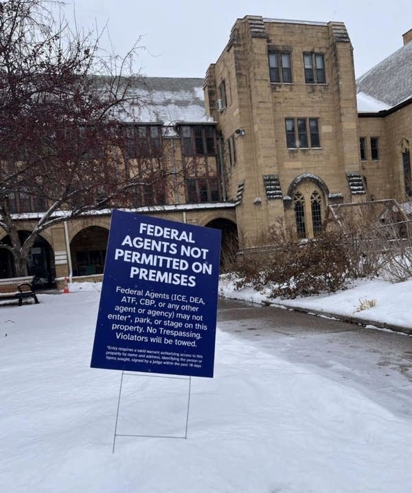 A sign posted outside of a building in snow